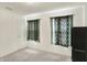 Light bedroom with two windows dressed in floral curtains, carpeted floors and dark shelving unit at 10828 Young Lake Dr, Indianapolis, IN 46229