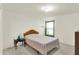 Bright bedroom featuring a window, simple bed, and side table with decor and carpeted floor at 10828 Young Lake Dr, Indianapolis, IN 46229