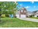 Attractive home featuring a well-maintained lawn, a two-car garage, and a vibrant blue front door at 10828 Young Lake Dr, Indianapolis, IN 46229