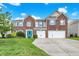 Charming two-story brick home with a well-manicured lawn, two-car garage, and a vibrant blue front door at 10828 Young Lake Dr, Indianapolis, IN 46229