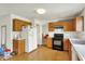 Efficient kitchen with light wood cabinets, laminate floors, and white appliances at 10828 Young Lake Dr, Indianapolis, IN 46229