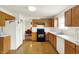 Bright kitchen with wood-look flooring, white appliances, and access to the dining room at 10828 Young Lake Dr, Indianapolis, IN 46229