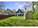 A spacious backyard with a blue house, shed, and grassy area offers ample outdoor space at 1130 W Congress Ave, Indianapolis, IN 46208