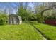 View of the backyard with a shed, lush grass and defined pathway at 1130 W Congress Ave, Indianapolis, IN 46208