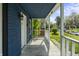 Open-air front porch with traditional railings, providing an unobstructed view of the charming blue home at 1130 W Congress Ave, Indianapolis, IN 46208