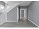 Bright living room featuring wood-look flooring, fresh gray paint, and a classic staircase at 1130 W Congress Ave, Indianapolis, IN 46208