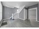 Sun-filled living room showcasing hardwood-style floors, fresh paint, and an elegant staircase at 1130 W Congress Ave, Indianapolis, IN 46208