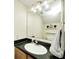 Powder room features a black countertop, large mirror, and modern vanity lighting at 11419 Pegasus Dr, Noblesville, IN 46060