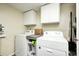 Convenient laundry room with white washer and dryer, storage cabinets, and neutral walls at 11419 Pegasus Dr, Noblesville, IN 46060