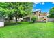A large green backyard with a spacious lawn, features mature tree and a pergola-covered deck at 11620 E 75Th St, Indianapolis, IN 46236