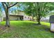 A verdant backyard showcases a pergola-covered deck, mature trees, and a well-maintained lawn at 11620 E 75Th St, Indianapolis, IN 46236