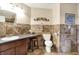 Tiled bathroom featuring a vanity with sink, toilet, and decorative wall art at 11620 E 75Th St, Indianapolis, IN 46236