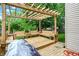 A wood deck features a pergola and built in seating, overlooking a verdant yard at 11620 E 75Th St, Indianapolis, IN 46236