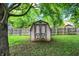 A wooden backyard shed with double doors is framed by trees and green grass at 11620 E 75Th St, Indianapolis, IN 46236