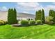 Lush backyard with a neatly kept lawn, privacy trees, and a quaint retaining wall at 12092 Sugar Creek Rd, Noblesville, IN 46060