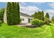 Beautiful lawn and backyard with large evergreen trees, privacy bushes, and concrete patio at 12092 Sugar Creek Rd, Noblesville, IN 46060