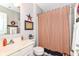 Cozy bathroom with patriotic decorations, vanity with white cabinets and red striped shower curtain at 12092 Sugar Creek Rd, Noblesville, IN 46060