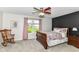 Cozy bedroom features a ceiling fan, bedside table, rocking chair, and a large window offering natural light at 12092 Sugar Creek Rd, Noblesville, IN 46060