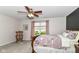 Cozy bedroom features a ceiling fan, bedside table, rocking chair, and a large window offering natural light at 12092 Sugar Creek Rd, Noblesville, IN 46060
