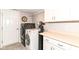 Bright laundry room with front loading washer and dryer, storage cabinets, folding counter, and water filtration system at 12092 Sugar Creek Rd, Noblesville, IN 46060