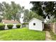 Well-maintained backyard with lush green grass, a white shed, and mature trees along the property line at 1309 N Colorado Ave, Indianapolis, IN 46201