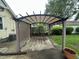 The backyard features a shaded pergola, a concrete patio, and established landscaping at 1309 N Colorado Ave, Indianapolis, IN 46201