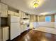Cozy kitchen featuring wood and tile floors, white cabinets, and stainless steel appliances at 1309 N Colorado Ave, Indianapolis, IN 46201