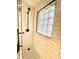 Modern shower featuring white subway tile, a glass block window, and dark fixtures at 1309 N Colorado Ave, Indianapolis, IN 46201