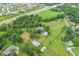 Expansive aerial view showcasing a property with a house, horse stable, and surrounding green pastures at 14655 Little Eagle Creek Ave, Zionsville, IN 46077