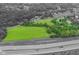Expansive aerial view of a lush property with a large green field and surrounding mature trees near a highway at 14655 Little Eagle Creek Ave, Zionsville, IN 46077