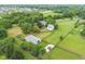 Aerial view of the property featuring a house, horse stable, paddocks, and well-manicured landscaping at 14655 Little Eagle Creek Ave, Zionsville, IN 46077