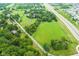An aerial view showcases expansive, verdant fields adjacent to a major highway and scattered residential areas at 14655 Little Eagle Creek Ave, Zionsville, IN 46077