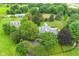 Aerial view highlighting a beautiful estate with meticulously manicured grounds and a charming home surrounded by lush greenery at 14655 Little Eagle Creek Ave, Zionsville, IN 46077
