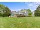 Expansive backyard featuring lush lawn, mature trees, and charming exterior of the home at 14655 Little Eagle Creek Ave, Zionsville, IN 46077