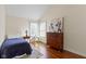 Cozy bedroom features hardwood floors, a twin bed, and a window with natural light at 14655 Little Eagle Creek Ave, Zionsville, IN 46077