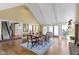 Formal dining room with hardwood floors, brick fireplace, vaulted ceilings, and large windows at 14655 Little Eagle Creek Ave, Zionsville, IN 46077