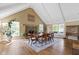Bright dining room with hardwood floors, brick fireplace, vaulted ceilings, and many windows at 14655 Little Eagle Creek Ave, Zionsville, IN 46077