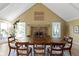 Formal dining room with hardwood floors, brick fireplace, vaulted ceilings, and many windows at 14655 Little Eagle Creek Ave, Zionsville, IN 46077