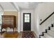 Inviting entryway with wooden chest, brick flooring and black accents creates an appealing and welcoming space at 14655 Little Eagle Creek Ave, Zionsville, IN 46077