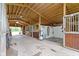 Clean horse stable featuring wooden stalls, concrete flooring, and natural light at 14655 Little Eagle Creek Ave, Zionsville, IN 46077