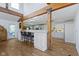Kitchen features white cabinetry, countertop seating, stainless appliances, wood columns and hardwood floors at 14655 Little Eagle Creek Ave, Zionsville, IN 46077