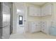 Bright kitchenette featuring white cabinetry, tile flooring, and an adjacent room at 14655 Little Eagle Creek Ave, Zionsville, IN 46077
