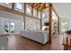 Open floor plan with wood beam vaulted ceiling, stone fireplace, and hardwood floors at 14655 Little Eagle Creek Ave, Zionsville, IN 46077