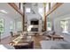 Living room with stone fireplace, vaulted ceiling, wood beams, natural light, and hardwood floors at 14655 Little Eagle Creek Ave, Zionsville, IN 46077
