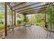 Cozy outdoor patio with wood pergola, seating, and lush greenery, perfect for relaxing at 14655 Little Eagle Creek Ave, Zionsville, IN 46077