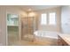 Bathroom featuring a walk-in shower, soaking tub, and double window for natural light at 16156 Oliver St, Fishers, IN 46037