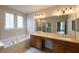 Bright bathroom featuring a double vanity, soaking tub, and a separate shower at 16156 Oliver St, Fishers, IN 46037