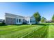 Exterior view of home featuring a sunroom, well-manicured lawn, and clear blue sky at 16156 Oliver St, Fishers, IN 46037