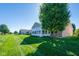 Exterior view with well-maintained lawn leading to sunroom, set against a clear blue sky at 16156 Oliver St, Fishers, IN 46037