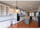 Open concept kitchen with white cabinetry, stainless steel appliances, and hardwood flooring at 16156 Oliver St, Fishers, IN 46037